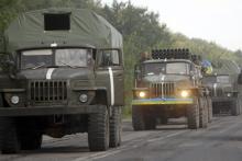 Ukrainian servicemen are seen inside army vehicles on a road in Donetsk region