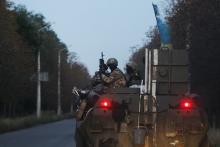 Ukrainian servicemen sit atop an armoured personnel carrier as they are transported to a military base in the eastern Ukrainian town of Kramatorsk