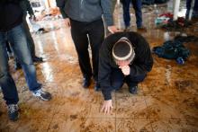 An Israeli settler touches the floor of a synagogue after it was evacuated during the second day of an operation by Israeli forces to evict the illegal outpost of Amona in the occupied West Bank, February 2, 2017. PHOTO BY REUTERS/Amir Cohen