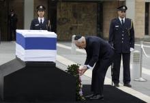 Israel's President Shimon Peres (C) lays a wreath near the flag draped coffin of former Israeli prime minister Ariel Sharon as he lies in state at the Knesset, Israel's parliament, in Jerusalem