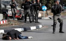 A Palestinian man lies on the ground after being shot by Israeli border policemen near the Jewish settlement of Beit El, near the West Bank city of Ramallah, December 15, 2017. PHOTO BY REUTERS/Goran Tomasevic