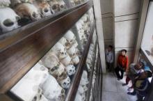 People look at skulls and bones of more than 8,000 victims of the Khmer Rouge regime during a Buddhist ceremony at Choeung Ek, a "Killing Fields" site located on the outskirts of Phnom Penh, April 17, 2015. PHOTO BY REUTERS/Samrang Pring