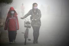 People walk along a street during a smoggy day in Jilin, Jilin province, October 22, 2013. PHOTO BY REUTERS/Stringer