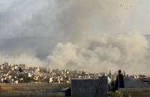 A man watches as smoke rises after what activists said was an air strike on Atimah, Idlib province, March 8, 2015. PHOTO BY REUTERS/Ammar Abdullah