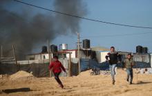 Palestinians run as smoke rises following what police said was an Israeli air strike on a Hamas post, in the northern Gaza Strip, February 6, 2017. PHOTO BY REUTERS/Mohammed Salem