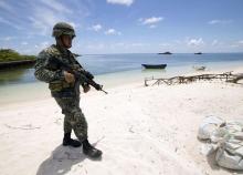 A Filipino soldier patrols at the shore of Pagasa island (Thitu Island) in the Spratly group of islands in the South China Sea, west of Palawan, Philippines, May 11, 2015. PHOTO BY REUTERS/Ritchie B. Tongo