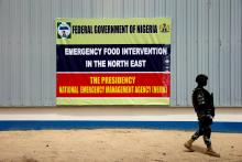 A soldier walks past a banner pasted on a warehouse where food and relief materials for the internal displaced persons are stored on the outskirts of Nigerian city of Maiduguri, Nigeria, June 8, 2017. PHOTO BY REUTERS/Akintunde Akinleye