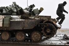 A Ukrainian serviceman jumps off a tank damaged during fighting with pro-Russian separatist forces, as it stays on a towing truck outside Debaltseve, eastern Ukraine, February 10, 2015. PHOTO BY REUTERS/Alexei Chernyshev