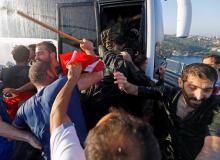 Soldiers push each other to board a bus to escape the mob after troops involved in the coup attempt surrendered on the Bosphorus Bridge in Istanbul, Turkey, July 16, 2016. PHOTO BY REUTERS/Murad Sezer