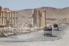 Syrian army soldiers drive past the Arch of Triumph in the historic city of Palmyra, in Homs Governorate, Syria, April 1, 2016. PHOTO BY REUTERS/Omar Sanadiki