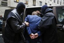 The Internal Security Agency (ABW) officers escort a man arrested on suspicion of spying in front of the district court in Warsaw