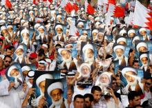 Anti-government protesters hold posters of Shi'ite cleric Ayatollah Sheikh Isa Qassim during an anti-government protest organised by Bahrain's main opposition group Al Wefaq, in Budaiya, west of Manama, Bahrain, May 17, 2013. PHOTO BY REUTERS/Hamad I Mohammed