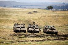 An Israeli soldier stands on a tank as another jumps off it near the Israeli side of the border with Syria in the Israeli-occupied Golan Heights, Israel May 9, 2018. PHOTO BY REUTERS/Amir Cohen