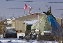 A tattered Canadian flag flies over a teepee in Attawapiskat, Ontario, December 17, 2011. PHOTO BY REUTERS/Frank Gunn