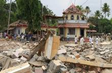 People stand next to debris after a broke out at a temple in Kollam in the southern state of Kerala, India, April 10, 2016. PHOTO BY REUTERS/Sivaram V