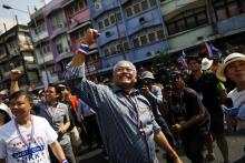 Protest leader Suthep Thaugsuban (C) greets his supporters as he leads thousands of anti-government demonstrators marching in Bangkok
