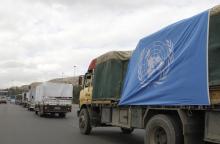 Trucks carrying food aid offered from UNRWA make their way to the besieged camp of al-Yarmouk south of Damascus, which is controlled by opposition fighters