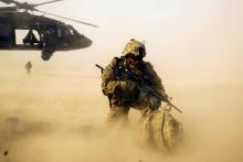 A U.S. soldier from the 3rd Cavalry Regiment shields himself from the rotor wash of a UH-60 Blackhawk helicopter after being dropped off for a mission with the Afghan police near Jalalabad in the Nangarhar province of Afghanistan, December 20, 2014. PHOTO BY REUTERS/Lucas Jackson