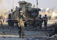 U.S. troops stand guard at the site of a suicide car bomb attack in Kabul