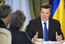 Ukraine's President Viktor Yanukovich (R) meets with journalists in Kiev