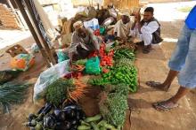 Customers look on as a vender displays fresh produce in Khartoum, Sudan, December 2, 2016. PHOTO BY REUTERS/Mohamed Nureldin Abdallah