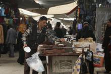 A vendor weighs nuts before selling them inside a market in Qamishli, Syria, April 11, 2016. PHOTO BY REUTERS/Rodi Said