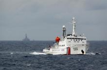 A Chinese Coast Guard vessel (R) passes near the Chinese oil rig, Haiyang Shi You 981 (L) in the South China Sea, about 210 km (130 miles) from the coast of Vietnam, June 13, 2014. PHOTO BY REUTERS/Nguyen Minh
