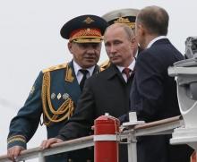 Russian President Vladimir Putin (C) and Defence Minister Sergei Shoigu (L) review the Russian fleet in Sevastopol, May 9, 2014. PHOTO BY REUTERS/Maxim Shemetov