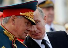 Russian President Vladimir Putin speaks with Defence Minister Sergei Shoigu as they attend the Navy Day parade in St. Petersburg, Russia, July 30, 2017. PHOTO BY REUTERS/Alexander Zemlianichenko