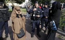 French police and gendarmes check identity cards of two women for wearing full-face veils, or niqab, as they arrived to demonstrate after calls on the internet by Islamic groups to protest over an anti-Islam video, in Lille, September 22, 2012. PHOTO BY REUTERS/Pascal Rossignol