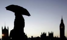A woman holds her umbrella as she walks across Westminster Bridge in front of Big Ben in London January 11, 2007. One man was killed as gale force winds and heavy rain caused severe disruption across parts of the country on Thursday, knocking down power lines and closing roads. PHOTO BY REUTERS/Luke MacGregor (BRITAIN)