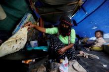 A woman makes bread inside her tent at a camp for internally displaced people near Sanaa, Yemen, May 24, 2016. PHOTO BY REUTERS/Khaled Abdullah