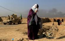 A woman who is fleeing the fighting between Islamic State and the Iraqi army in the Intisar district of eastern Mosul, walks past a military humvee while heading to safer territory in Iraq, November 7, 2016. PHOTO BY REUTERS/Zohra Bensemra