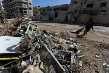 A woman walks past debris along a street in Aleppo's Belleramoun Industrial Zone, Syria, February 2, 2017. PHOTO BY REUTERS/Omar Sanadiki