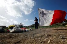 A woman pays her respects at the scene of the assassination of investigative journalist Daphne Caruana Galizia, killed in a car bomb attack a week ago, alongside the road leading from her home in Bidnija, Malta, October 23, 2017. PHOTO BY REUTERS/Darrin Zammit Lupi