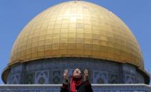 A Palestinian woman prays in front of the Dome of the Rock on the first Friday of the holy month of Ramadan at the compound known to Muslims as the Noble Sanctuary and to Jews as Temple Mount, in Jerusalem's Old City, June 19, 2015. PHOTO BY REUTERS/Ammar Awad