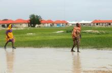 Women walk through flood waters at Bakassi camp, Borno, Nigeria, July 18, 2017. PHOTO BY REUTERS/Afolabi Sotunde