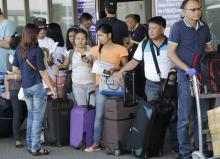 Overseas Filipino Workers (OFW) wait outside before boarding a flight at an international airport in Manila, January 12, 2015. PHOTO BY REUTERS/Romeo Ranoco
